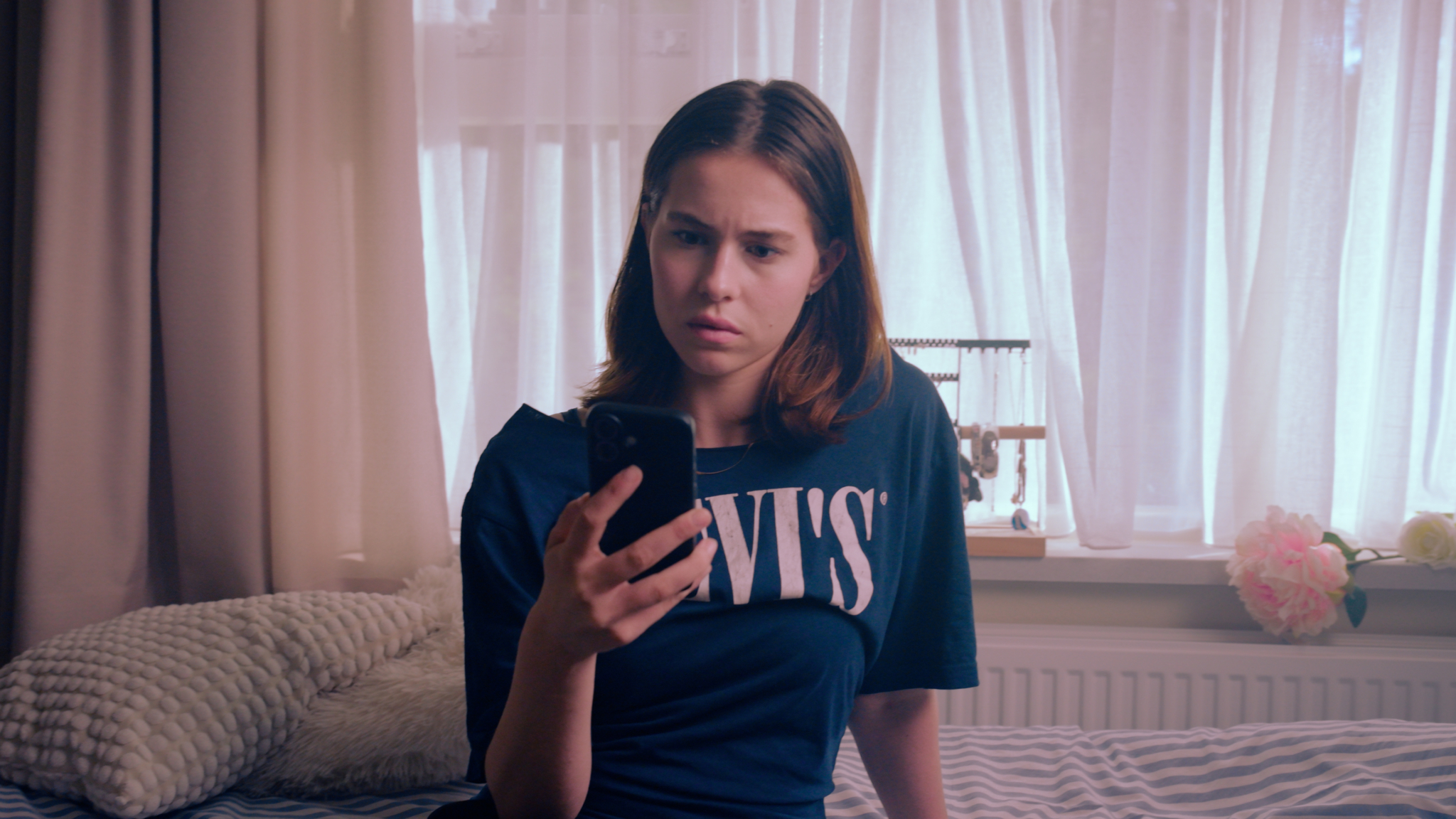 meisje kijkt verbaasd naar telefoon